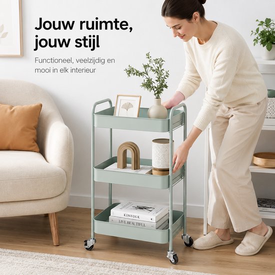 Chariot de cuisine vert menthe dans un salon avec des objets décoratifs et des livres, utilisé par une femme.