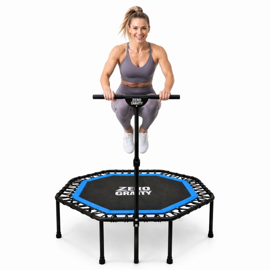 Vrouw springt op achthoekige trampoline met handgreep. Trampoline met blauwe rand en 'Zero Gravity' logo.