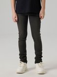 Jongen in een grijze slim fit spijkerbroek, met witte sneakers.