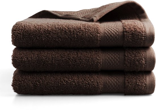 Trois serviettes marron empilées avec un motif subtil sur le dessus.