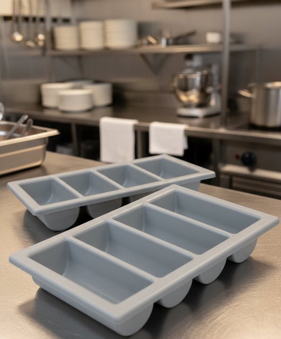 Twee grijze bestekbakken met vier vakken op een roestvrijstalen tafel in een keuken.