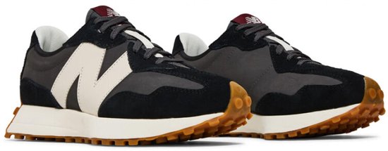 Twee zwarte New Balance sneakers met beige 'N' logo, witte zolen en bruine profielzolen.