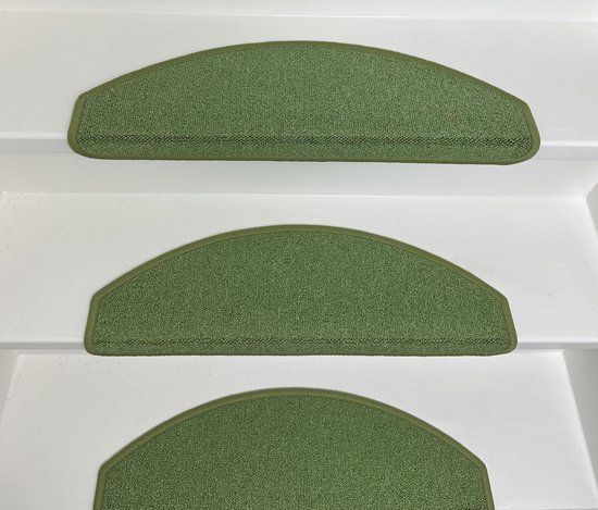 Groene halve maan trapmatten op witte traptreden.