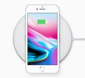 Wit iPhone 8 op een witte draadloze oplader, 75% opgeladen.