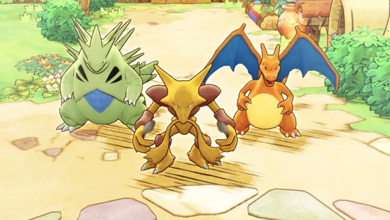 Tyranitar, Alakazam en Charizard staan in een woestijnlandschap.