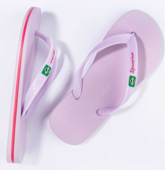 Lichtpaarse Ipanema slippers met rode accenten op de zoolrand en Braziliaanse vlag op de bandjes.