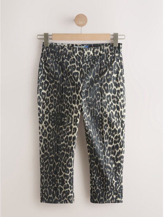 Capri-jeans met luipaardprint hangend aan een kapstok.