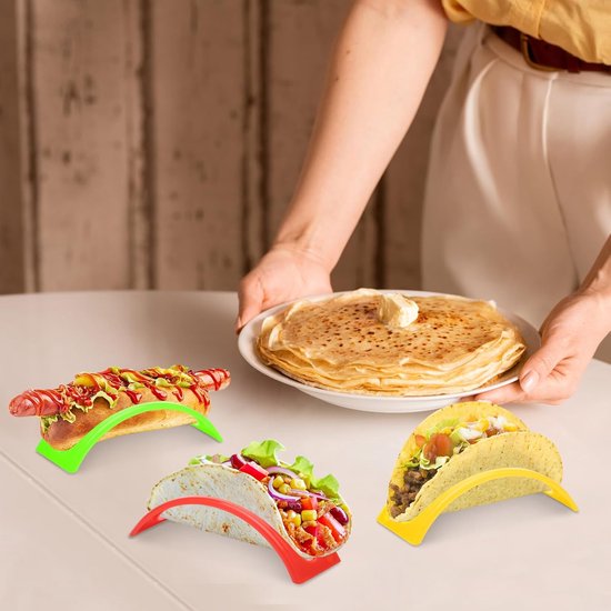 Gevulde taco's en een hotdog in rode, rode en gele houders op een tafel. Een stapel pannenkoeken wordt aangereikt.