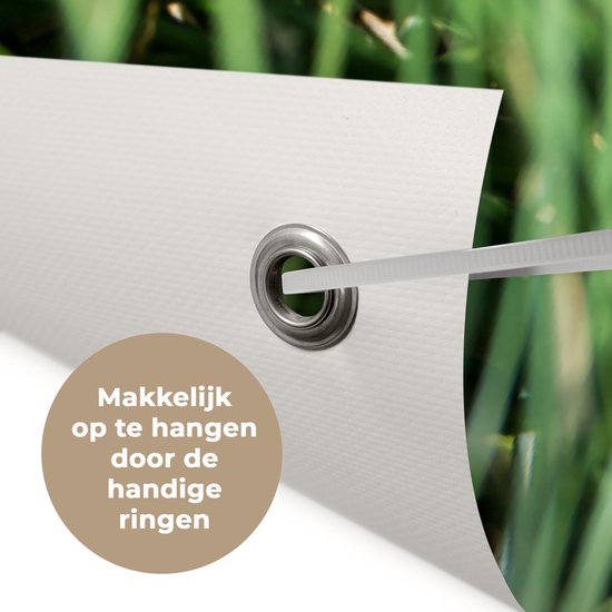 Tuinposter 180x120 cm - Tuindecoratie Aap - Jong - Gras - Slapen - Poster voor in de tuin - Buiten decoratie - Schutting tuinschilderij - Tuindoek muurdecoratie - Wanddecoratie balkondoek