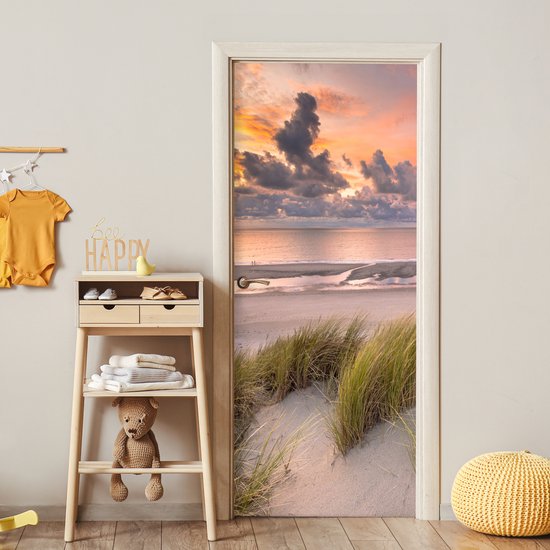 Deurposter met duinlandschap bij zonsondergang boven de zee.