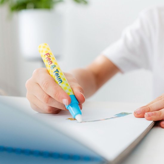 Kind hand met gele, geruite Fien & Teun waterpen met blauwe dop, kleurt in een boekje.