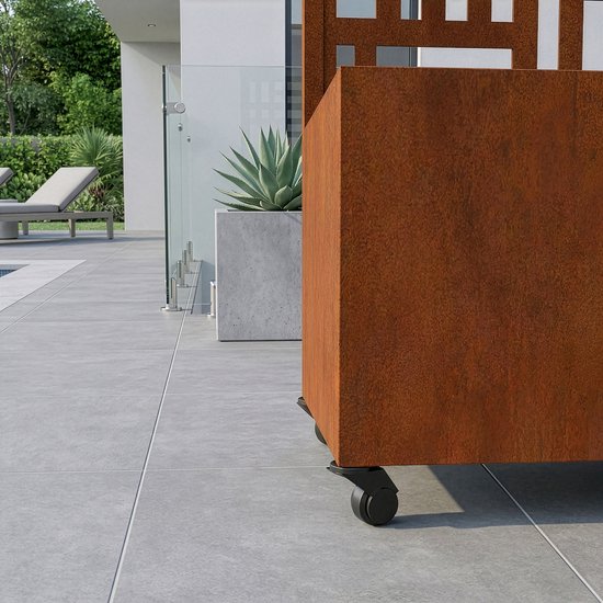 Roestkleurige plantenbak op wieltjes naast een huis met een glazen schuifpui.