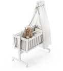 Wit kinderbed met hemel, ruitjespatroon, en teddybeer.