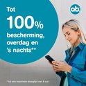 Vrouw kijkt op telefoon, met tekst 'Tot 100% bescherming, overdag en 's nachts'.