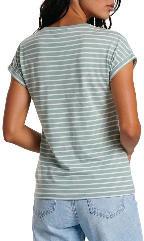 Vrouw van achteren gezien, draagt een groene top met witte strepen en blauwe jeans.