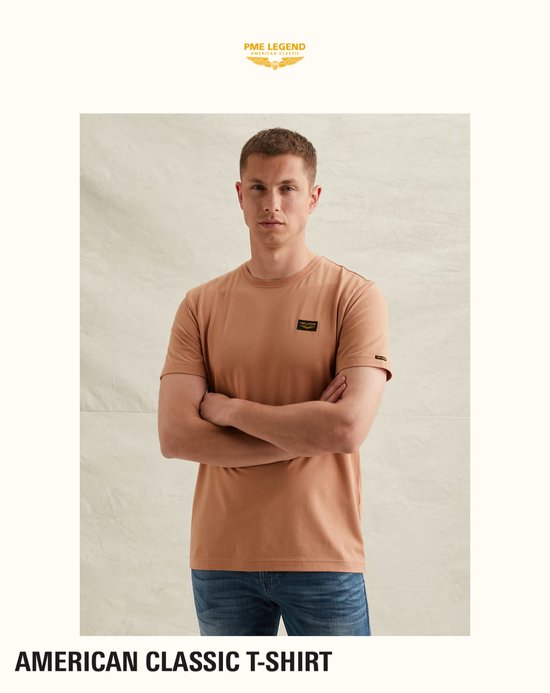 Mannequin portant un t-shirt PME Legend brun clair avec écusson et un jean.