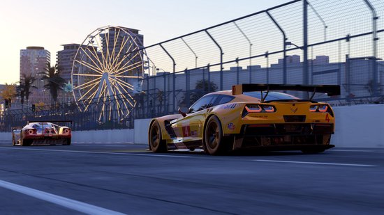 Oranje Chevrolet Corvette racewagen met nummer 4 op een circuit, reuzenrad op achtergrond.