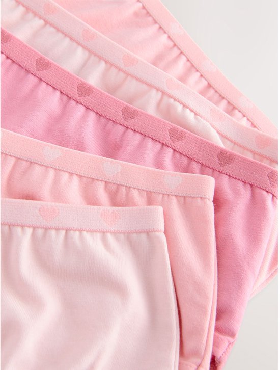Detailopname van de tailleband van slips in roze tinten met hartjespatroon.