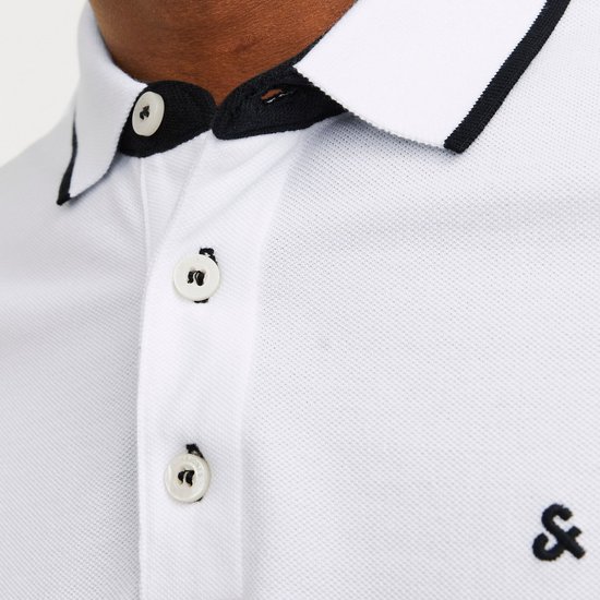 Close-up van de knoopjes en kraag van een witte polo met zwarte bies.