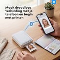 Een hand houdt een telefoon met een ID-foto van een vrouw voor een Silvergear printer. Een ID-paspoort ligt ernaast.