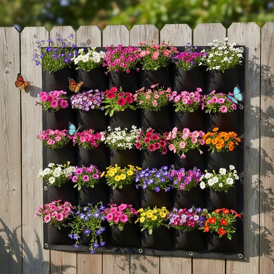 Zwarte verticale tuin met 36 vakjes, versierd met veelkleurige bloemen en vlinders, gemonteerd op een houten schutting.
