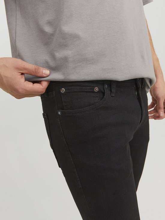 Detail van de voorkant van een strakke zwarte jeans