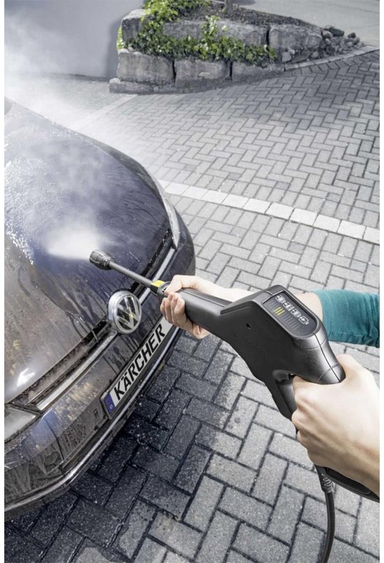 Hand met hogedrukreiniger spuitend op de voorkant van een auto.