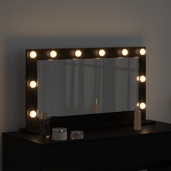 Miroir de maquillage noir éclairé avec 12 ampoules, avec des cosmétiques dessus.