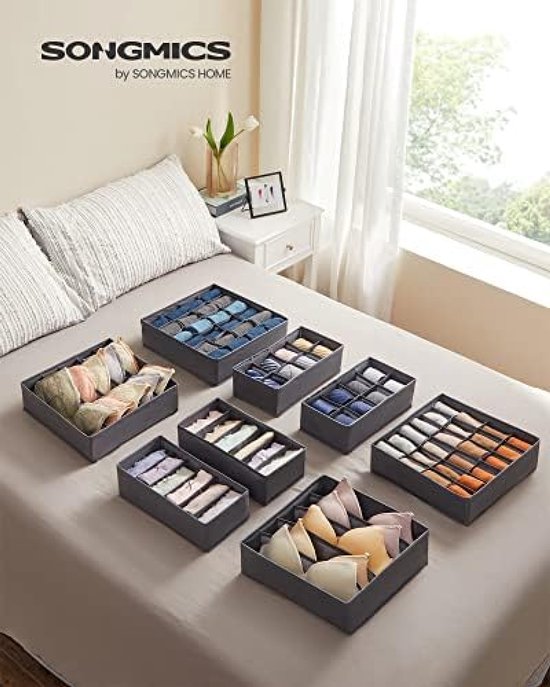 Organisateurs de tiroir remplis de soutiens-gorge, chaussettes et cravates, disposés sur un lit. Nom de marque SONGMICS.