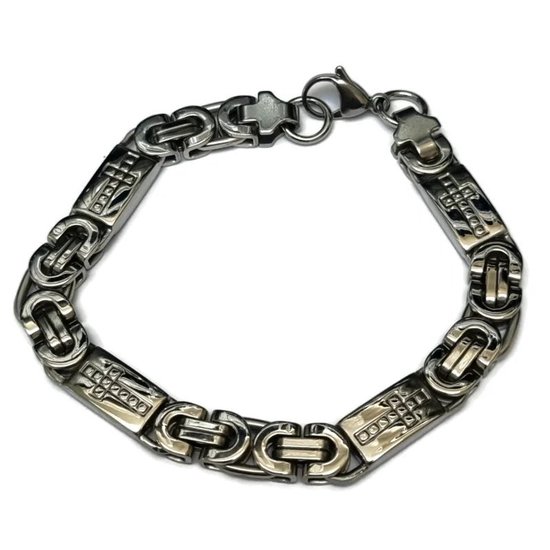 Bracelet à maillons argentés de type 'King's Link' avec des croix, posé sur un fond blanc.