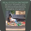 Jongetje speelt met houten treinbaan met station, brug en voertuigen.