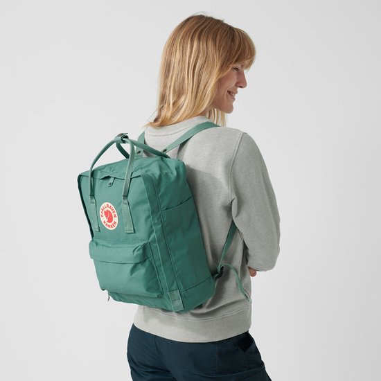 Groene Fjällräven Kånken rugzak gedragen door een vrouw.