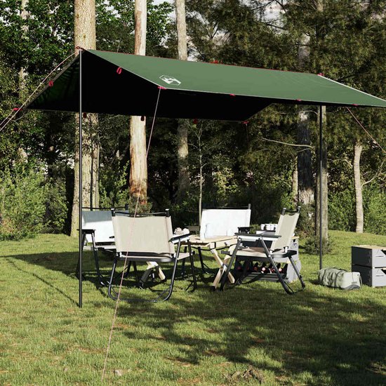 Bâche de camping verte au-dessus d'une table et de chaises de camping dans une forêt.