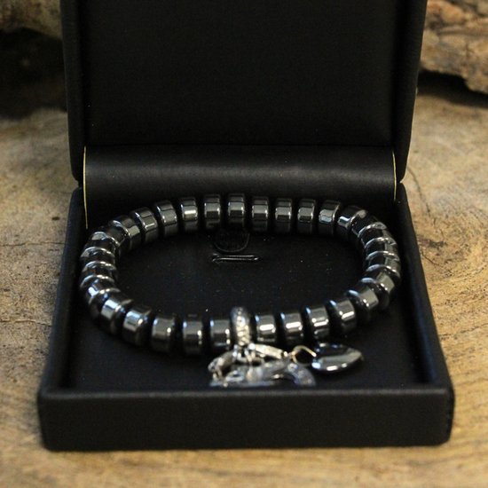Hematiet armband met facet geslepen kraaltjes en een zilverkleurige cirkelbedel met zirkonia.