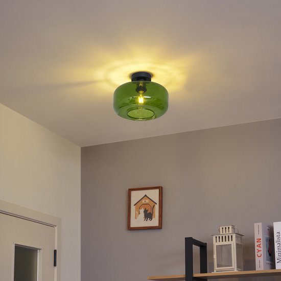 Groene glazen plafondlamp gemonteerd aan een plafond in een woonkamer.