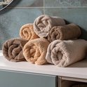 Pile de serviettes beiges et brunes sur un lavabo.