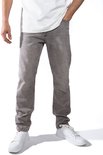 Detailopname van een man in een witte t-shirt en grijze jeans.