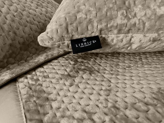 Close-up van bronskleurige kussenslopen met gedetailleerd patroon en LINNICK logo.