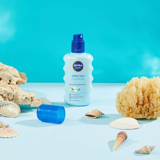 Lichtblauwe NIVEA After Sun sprayfles omringd door schelpen en sponzen op een blauwe achtergrond.
