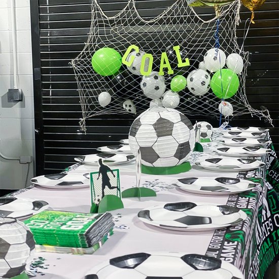 Tafel gedekt met voetbaldecoraties, servies en de tekst 'GOAL'.