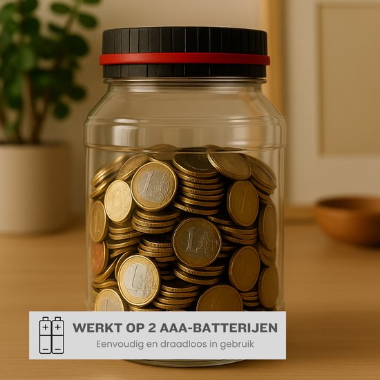 Transparante spaarpot vol met euro munten, geplaatst op een houten tafel. De deksel is zwart met een rode ring. Tekst geeft aan dat de pot werkt op 2 AAA-batterijen.