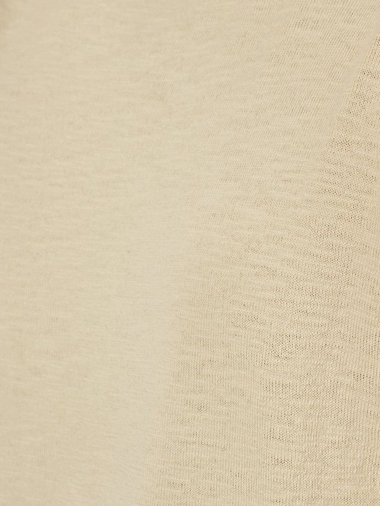 Gros plan du tissu beige à la texture tricotée fine.