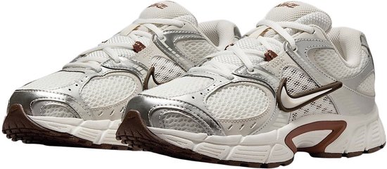 Paire de baskets Nike V5 pour femmes blanches avec accents argentés et marrons.