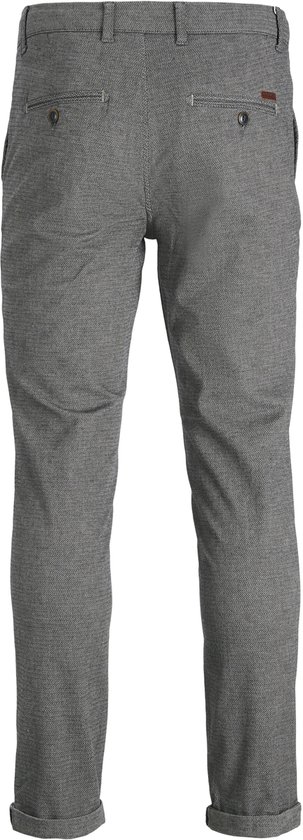 Achterkant van een grijze broek met fijne structuur, met opgerolde broekspijpen.