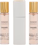 Drie flacons Coco Mademoiselle Eau de Toilette van Chanel met gouden dopjes, naast een zilverkleurige verstuiver.