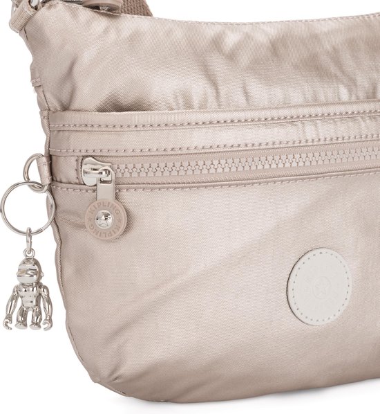 Detail van de zilverkleurige rits en aapjeshanger aan een lichtgrijze Kipling tas.