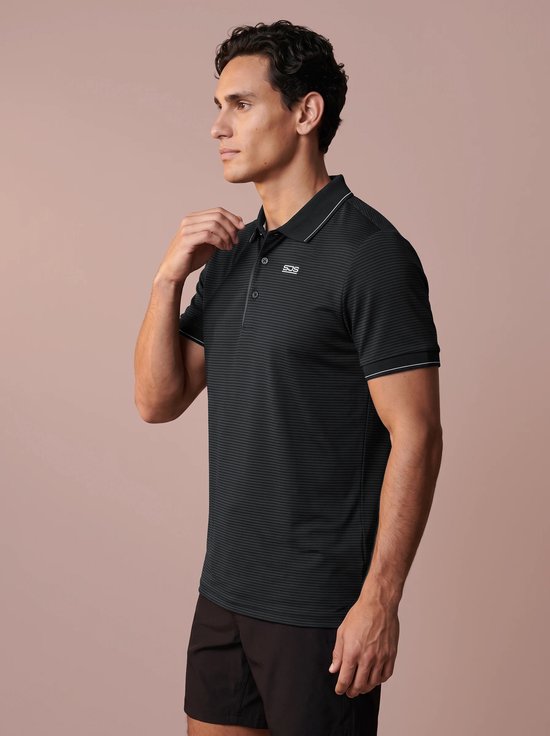 Zijaanzicht van een model in een zwart-grijs gestreept Sjeng Sports poloshirt met logo op de borst.