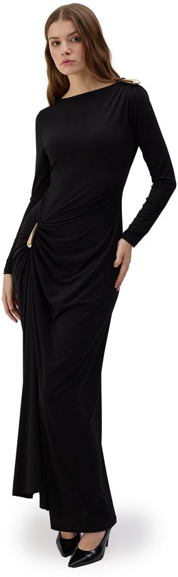Zwarte maxi-jurk met lange mouwen, gouden gespdetail in de taille en op de schouder, gedragen door een model.