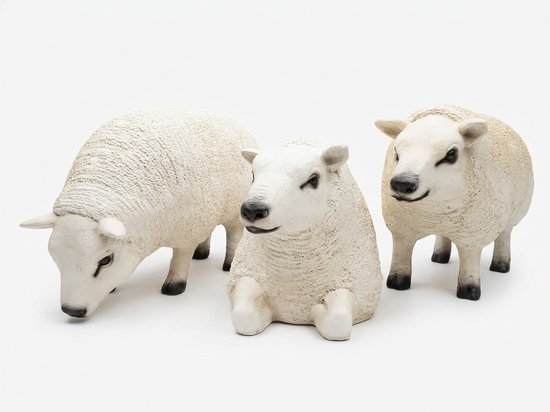 Set van drie crèmekleurige schapenbeelden: grazend, liggend en staand op witte achtergrond.