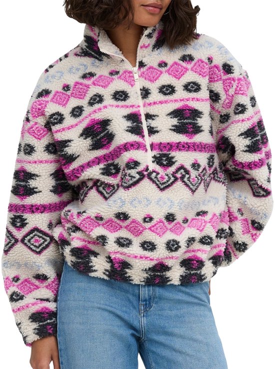 Model draagt een crèmekleurige teddy sweater met roze, zwart en blauw Azteeks patroon en rits bij de hals.